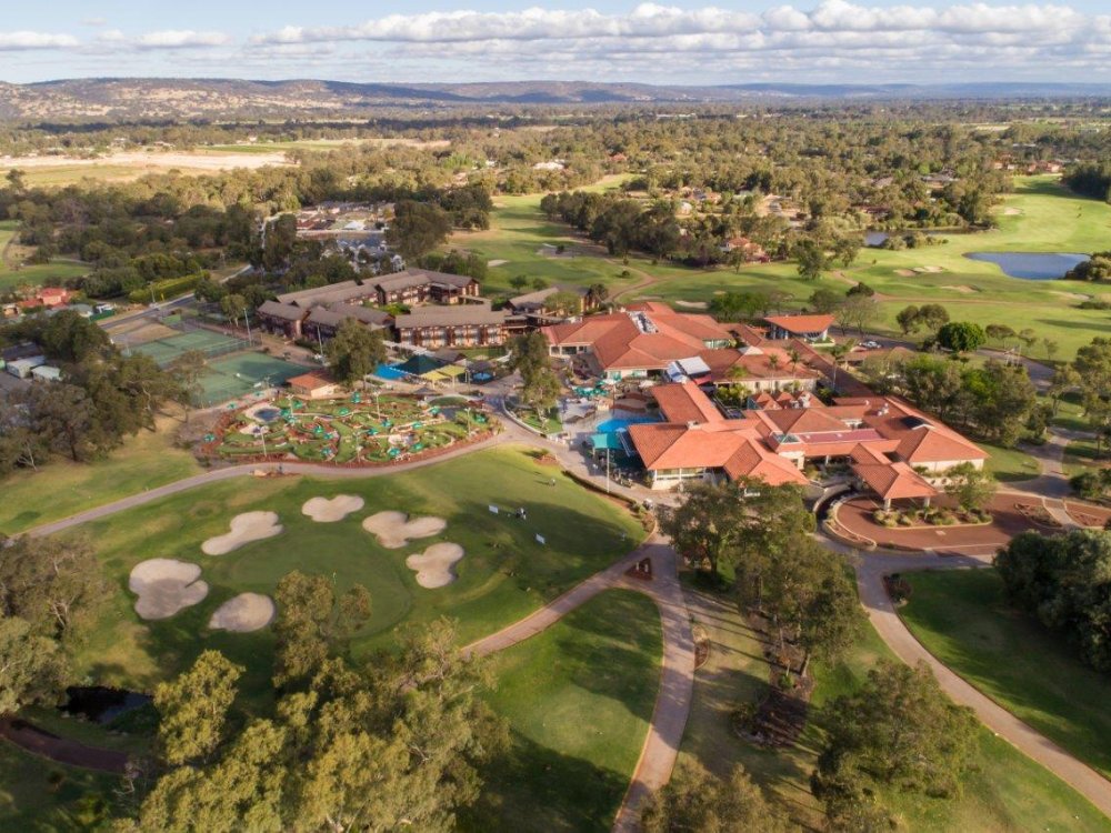 Aerial view of a large resort complex featuring golf courses, mini-golf, tennis courts, and multiple buildings.